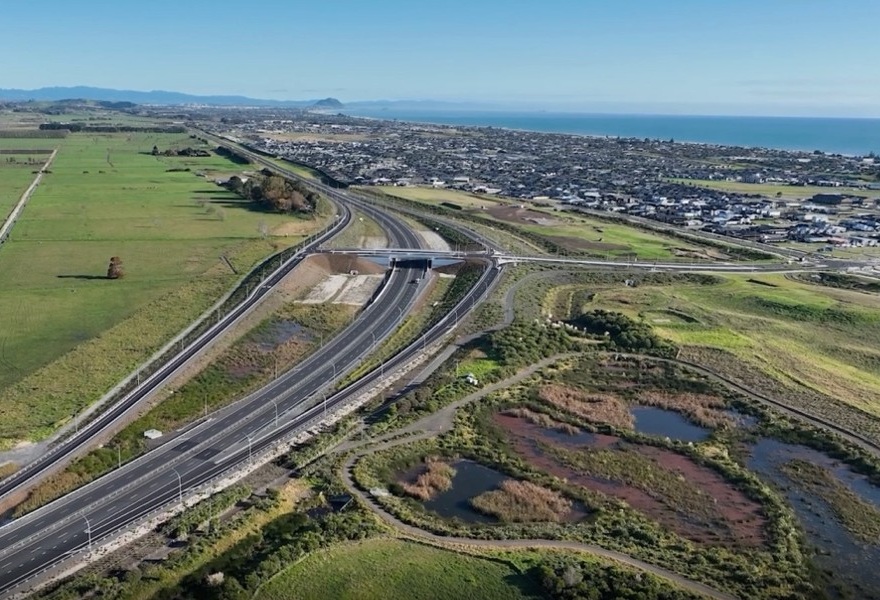 An aerial view of the Wairākei Interchange looking east, with the nature walk around wetland Horoipia in the foreground Aerial view of construction progress
